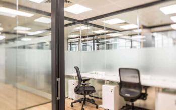 Modern office space rental at Bleicherweg 10, Zürich Enge with partitioned desks and ergonomic chairs.